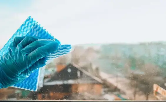 Bayeta de microfibra sobre un cristal durante la limpieza de una ventana