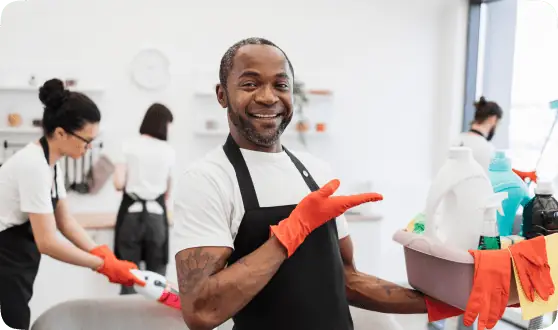 Trabajador de limpieza con delantal y productos en un alojamiento de Barakaldo